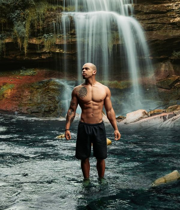 Man in a power pose feeling balanced and strong in a bright environment.